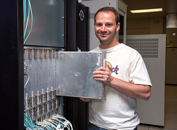 Paul Peltz, LANL HPC Scalable Systems Engineer, slides one of the Knights Landing boards into one of the first Trinity supercomputer’s cabinets. (Photo courtesy LANL)